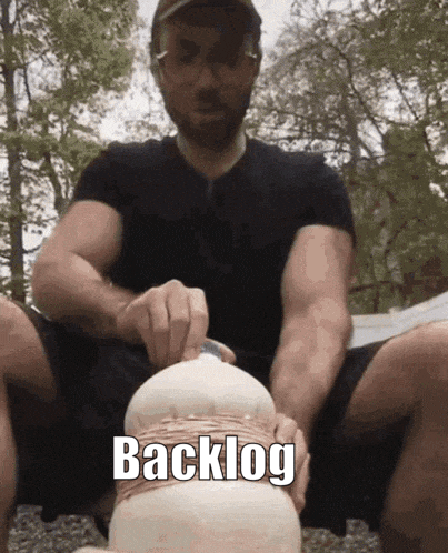 Man in Black Shirt Holding Object With Backlog