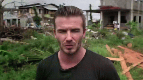 Man in Black Shirt in Field With House