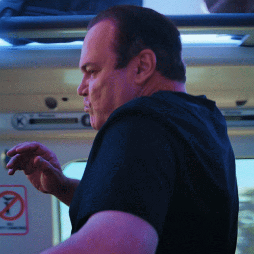 Man in Black Shirt in Front of No Smoking Sign