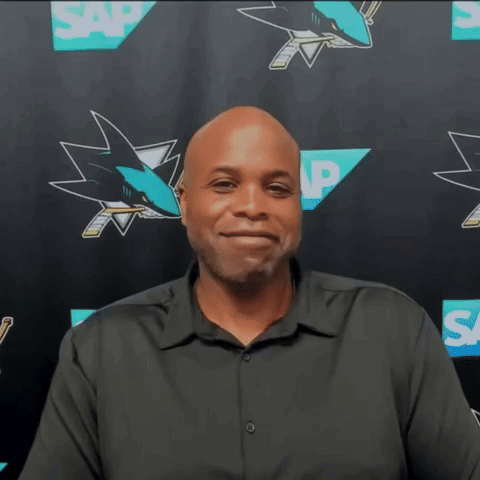 Man in Black Shirt in Front of SAP Sharks Logos
