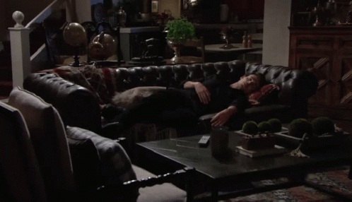 Man In Black Shirt Laying On Leather Couch GIF