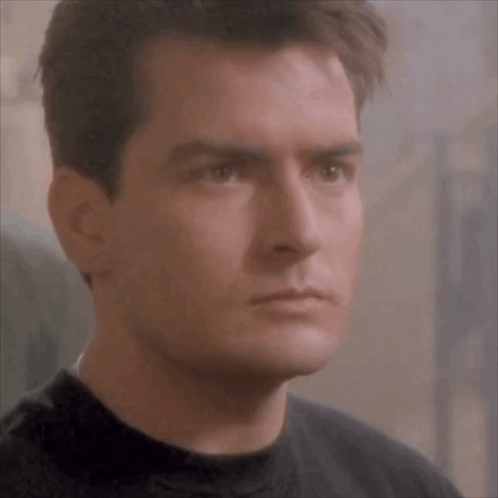 Man In Black Shirt Looking At Camera GIF
