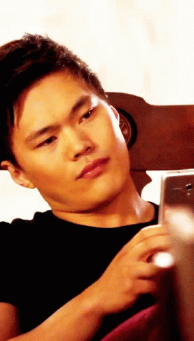 Man In Black Shirt Looking At Phone GIF