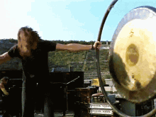 Man In Black Shirt Playing Gong GIF