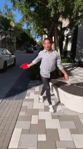 Man In Black Shirt Reaching Toward Lamp With Clueless GIF