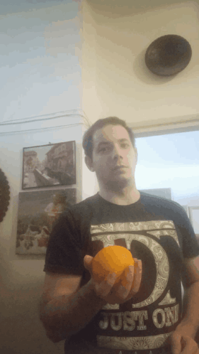 Man In Black Shirt Saying Just Holding Orange GIF