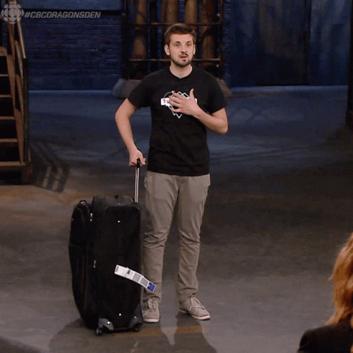 Man in Black Shirt Saying Skyscraper Pushing Suitcase