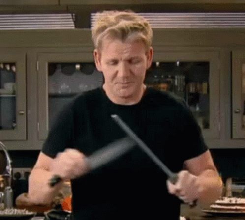 Man in Black Shirt Sharpening Knife