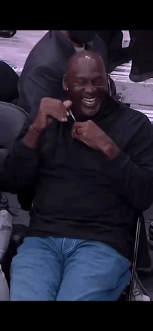 Man In Black Shirt Sitting In Chair Smiling GIF