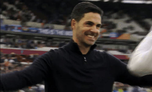 Man In Black Shirt Smiling Arms Outstretched In Front Of Crowd GIF