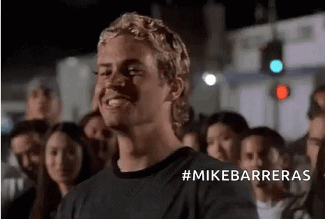 Man in Black Shirt Smiling Before Crowd