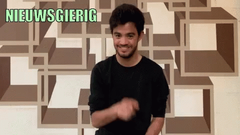 Man in Black Shirt Smiling In Front of Nieuwsgierig Wall