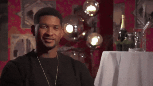 Man In Black Shirt Smiling Next To Wine Bottle GIF