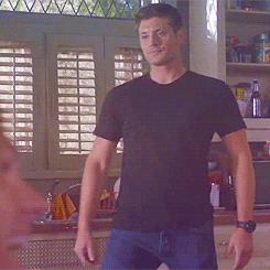 Man In Black Shirt Standing In Front Of Window GIF