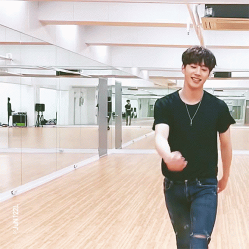 Man In Black Shirt Standing In Mirrored Room GIF