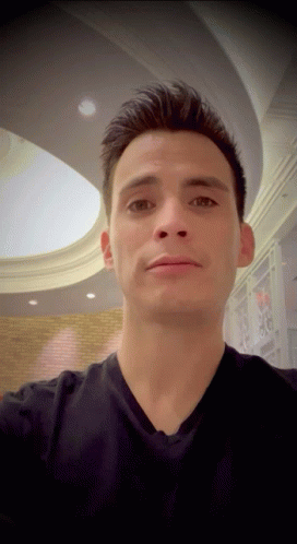 Man In Black Shirt Taking Selfie Under Ceiling GIF