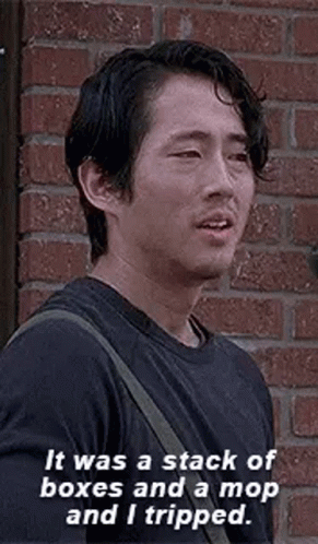 Man in Black Shirt Talking in Front of Brick Wall