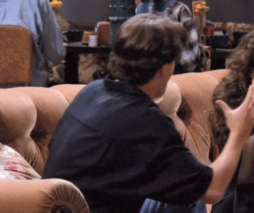 Man in Black Shirt Talking to Woman on Couch