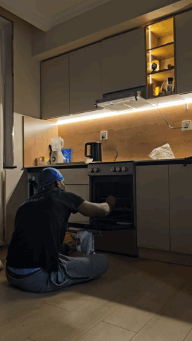 Man in Black Shirt with A Kneeling at Oven