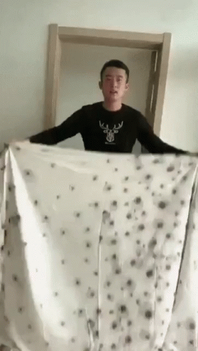 Man In Black Shirt With Deer Holding Blanket GIF