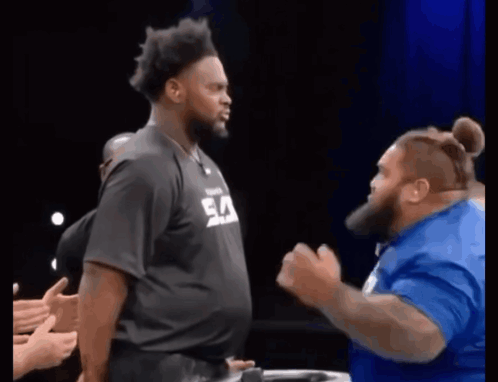 Man in Black Shirt with Ea Next to Man in Blue