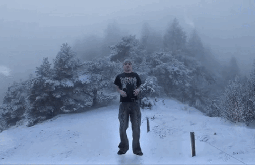 Man In Black Shirt With Heavy Metal In Snow GIF