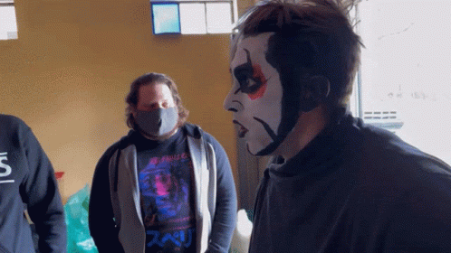 Man in Black Shirt with S Next to Face Painted Man