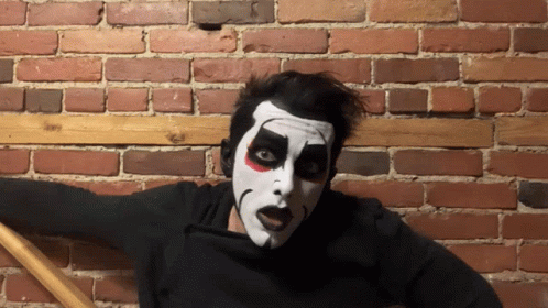 Man in Black Shirt with S Next to Face Painted Man