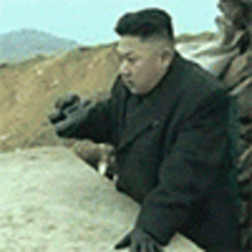 Man in Black Suit and Gloves Standing in Dirt