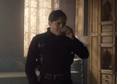 Man in Black Suit Drinking from Glass