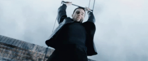 Man In Black Suit Hanging On Rope GIF