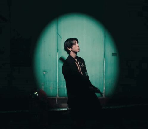 Man in Black Suit in Front of Green Door