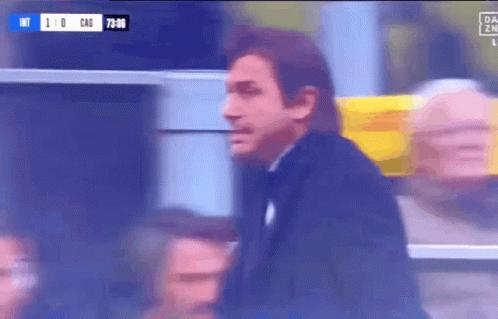 Man In Black Suit In Front Of Scoreboard Saying 1-0 GIF