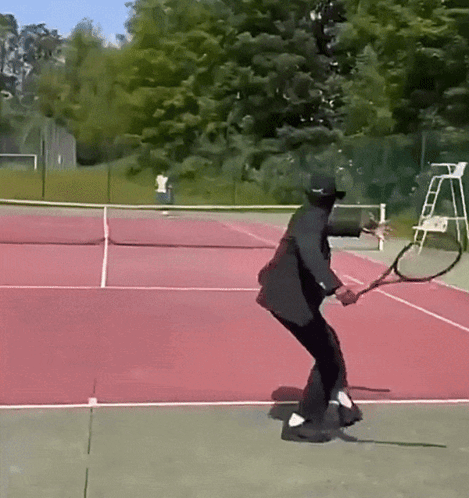 Man in Black Suit Swinging Tennis Racquet