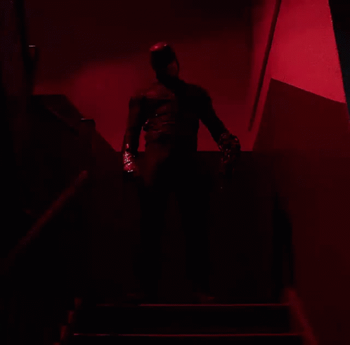 Man in Black Suit Walking Down Stairs