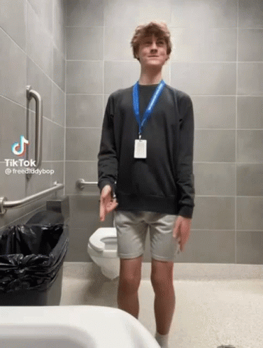 Man in Black Sweater and Grey Shorts Beside Toilet