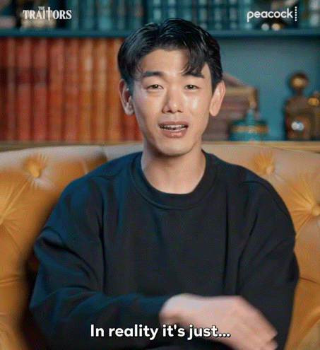 Man In Black Sweater On Yellow Couch Saying In Reality It's Just GIF
