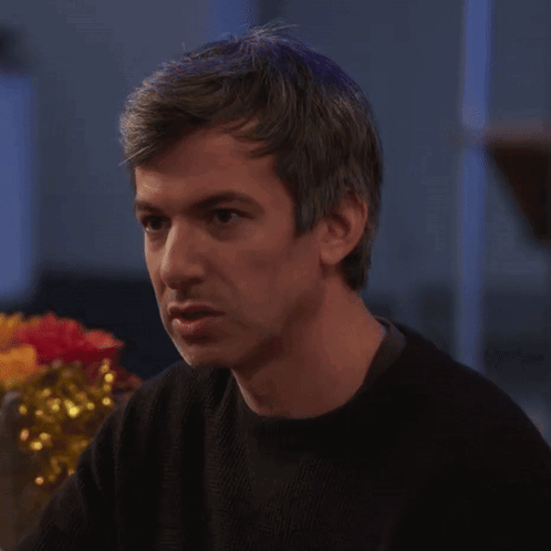 Man in Black Sweater Sitting at Table