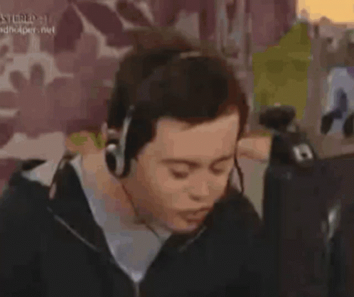 Man In Black Sweater Sitting In Front Of Purple Wall GIF