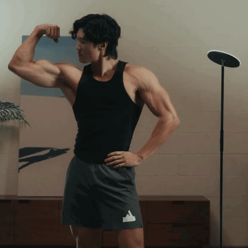 Man in Black Tank Top Flexing Arm