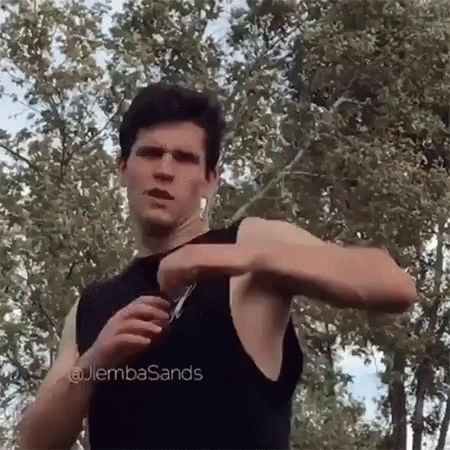 Man in Black Tank Top Holding Scissors