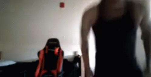 Man in Black Tank Top in Front of Red and Black Chair