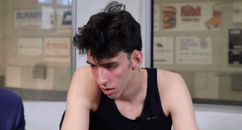 Man in Black Tank Top Sitting by Burger King Sign