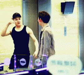 Man in Black Tank Top Talking to Man in Grey Jacket