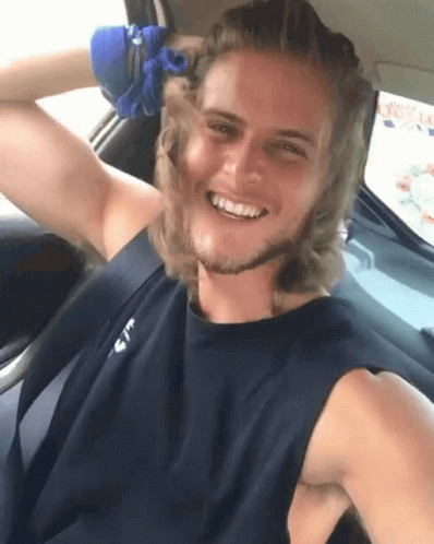Man in Black Tank Top With Letter T Smiling in Car