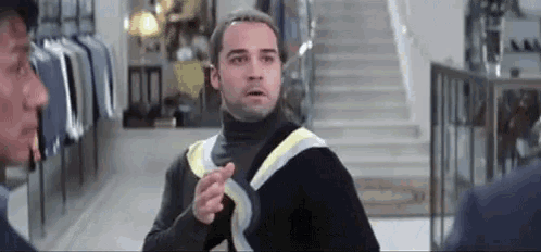 Man In Black Turtleneck Pointing At Another Man GIF