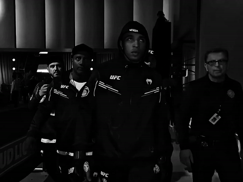 Man In Black UFC Jacket Walking With Security Guard GIF