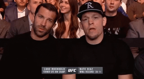 Man in Black UFC Shirt Standing Next to Another Man