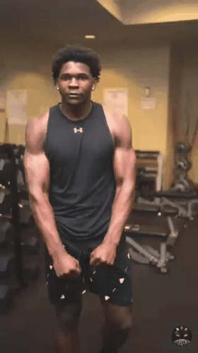 Man in Black Under Armour Tank Stretches