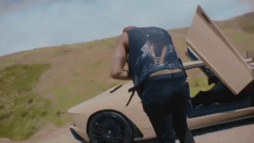 Man in Black Vest Next to Car Hood